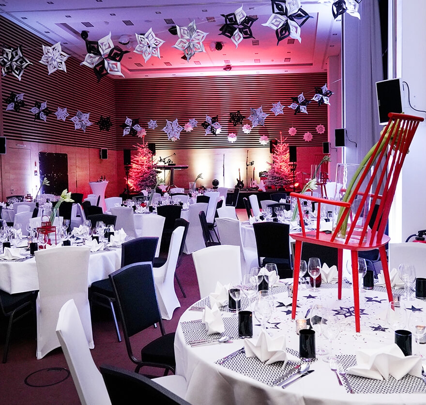 Aufnahme in der Eventlocation am Tegernsee mit mehreren gedeckten Tischen und Dekoration in schwarz-weißen Farben.